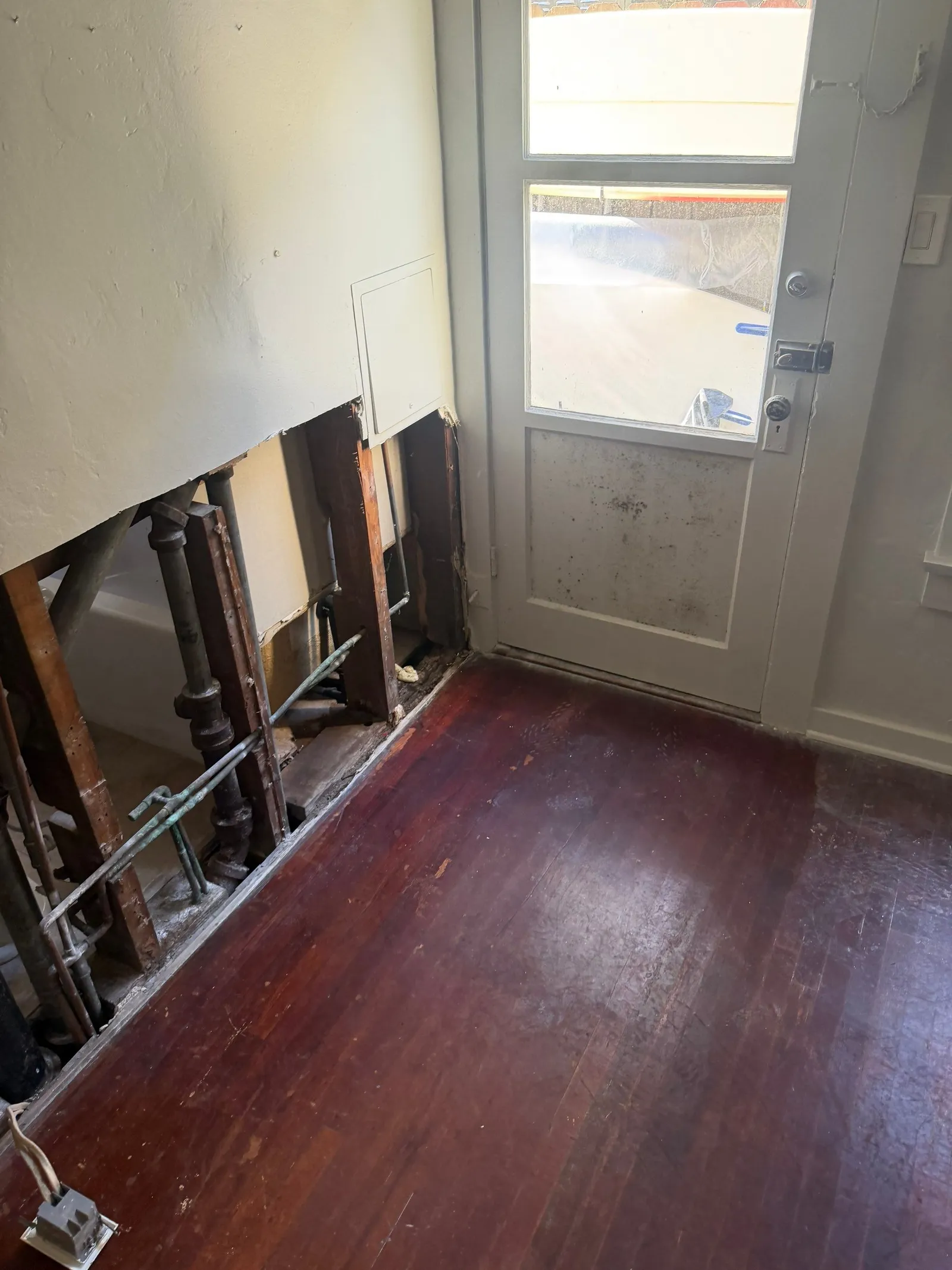 Bedroom wall opened at the base to remove saturated drywall