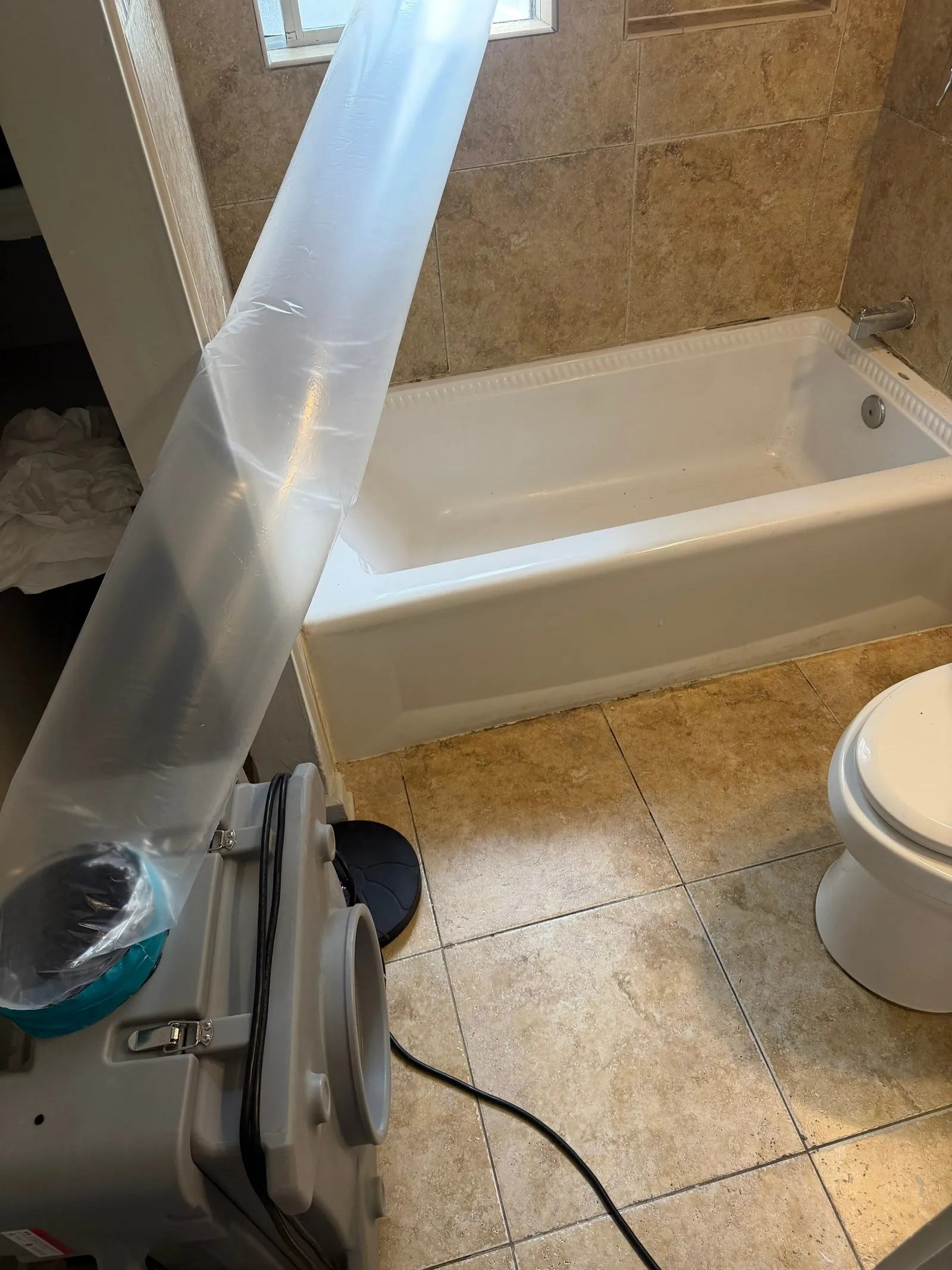 Bathroom drying behind a plastic containment barrier