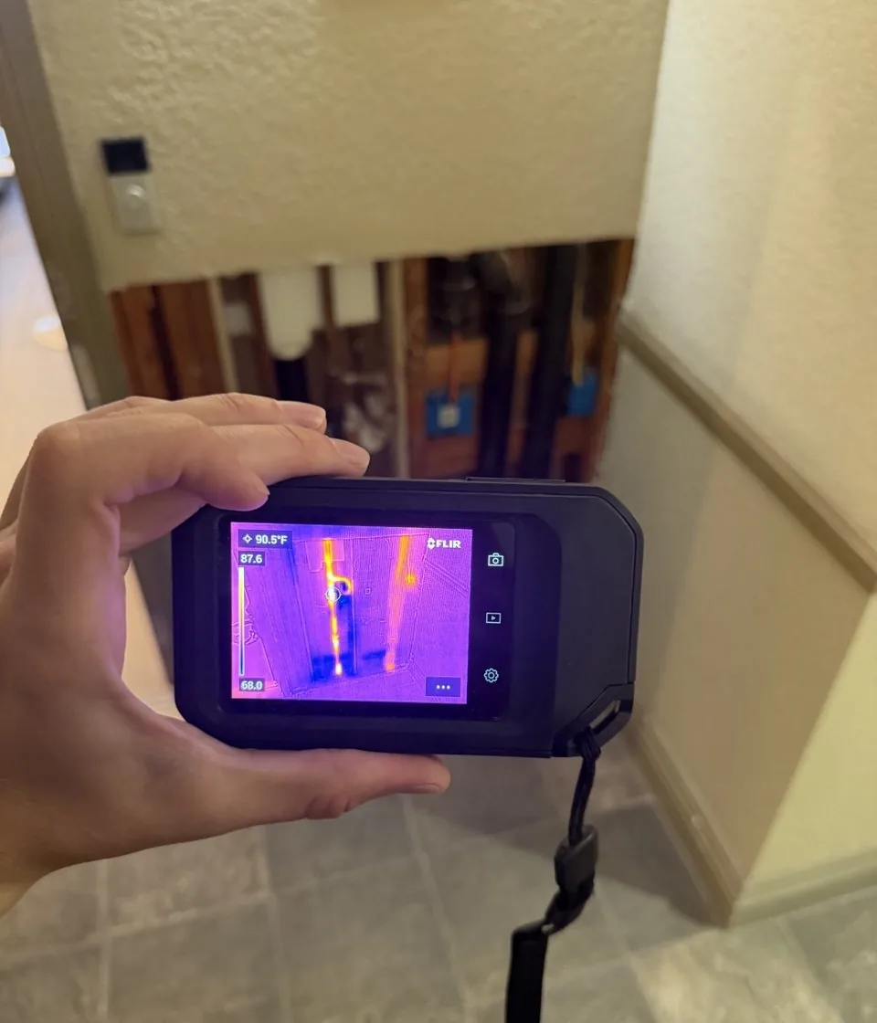 Thermal camera showing water lines inside an opened condo wall